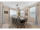 Dining room with modern chandelier, neutral walls, tile floors, and backyard views at 40610 W Desert Fairways Dr, Maricopa, AZ 85138