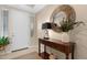 Inviting foyer featuring a console table with drawers, a round mirror, and light tile flooring at 40610 W Desert Fairways Dr, Maricopa, AZ 85138