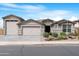 Charming home featuring a three-car garage and an inviting desert landscape, showcasing its appealing curb appeal at 40610 W Desert Fairways Dr, Maricopa, AZ 85138