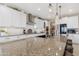 Beautiful kitchen island with barstool seating, granite counters, sink, and stainless appliances at 40610 W Desert Fairways Dr, Maricopa, AZ 85138