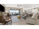 Bright living room with large windows overlooking the lake, designer furniture, and decor at 40610 W Desert Fairways Dr, Maricopa, AZ 85138