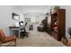 Bright Office with a desk and rolling chairs, plus a bookshelf and accent chair, offering functionality and style at 40610 W Desert Fairways Dr, Maricopa, AZ 85138