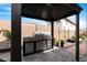 Outdoor kitchen featuring built in BBQ and stone flooring at 40610 W Desert Fairways Dr, Maricopa, AZ 85138