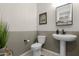 Stylish powder room with modern fixtures, half wall, and decorative accents for guests at 40610 W Desert Fairways Dr, Maricopa, AZ 85138