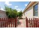 Backyard with a brick pathway, lush greenery, and a view of the home's exterior at 4313 N 161St Ave, Goodyear, AZ 85395