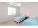 Bright bedroom with two twin beds, neutral carpeting, and a ceiling fan at 4313 N 161St Ave, Goodyear, AZ 85395