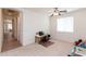 Spacious carpeted bedroom with a ceiling fan, a window, and an adjacent sitting room at 4313 N 161St Ave, Goodyear, AZ 85395