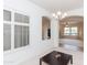 Bright dining room with a modern chandelier and plantation shutters, with an open arch to living area at 4313 N 161St Ave, Goodyear, AZ 85395