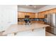 Updated kitchen boasts granite counters, stainless steel appliances, wood cabinetry, and double door access to a pantry at 4313 N 161St Ave, Goodyear, AZ 85395