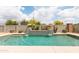 This in-ground pool has a raised tile feature with two waterfalls under flower-filled pots at 4313 N 161St Ave, Goodyear, AZ 85395