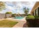 This in-ground pool is surrounded by grass, shrubbery, a brick wall and a brick path at 4313 N 161St Ave, Goodyear, AZ 85395