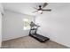 This bedroom has carpet and a treadmill near the window, which offers natural light at 4445 E Coconino St, Phoenix, AZ 85044