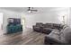 Spacious living room featuring plank flooring, a ceiling fan, and comfortable gray seating at 4445 E Coconino St, Phoenix, AZ 85044