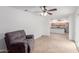 Spacious living room with tiled flooring, a ceiling fan, and a comfortable gray chair at 4445 E Coconino St, Phoenix, AZ 85044