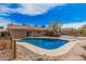 Spacious backyard with a blue pool, a hot tub, a fire pit, and lush landscaping, perfect for entertaining at 4445 E Coconino St, Phoenix, AZ 85044
