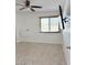Bright bedroom featuring neutral carpet, a ceiling fan, a large window, and a mounted TV at 461 W Holmes Ave # 374, Mesa, AZ 85210