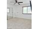 Light-filled bedroom featuring mirrored closet doors, neutral carpet, a ceiling fan, and a mounted TV at 461 W Holmes Ave # 374, Mesa, AZ 85210