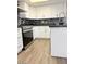 Renovated kitchen featuring white cabinets, black countertops, stainless steel appliances, and backsplash at 461 W Holmes Ave # 374, Mesa, AZ 85210