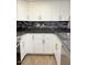 Updated kitchen with white cabinets, black countertops, backsplash, and stainless steel appliances at 461 W Holmes Ave # 374, Mesa, AZ 85210