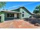 Rear exterior of the home with a covered patio, rock landscaping, and a small concrete patio area at 5153 W Topeka Dr, Glendale, AZ 85308