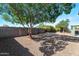 A gravel backyard offering shade from a mature tree and surrounded by a block wall at 5153 W Topeka Dr, Glendale, AZ 85308
