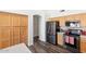 Kitchen featuring light wood cabinets, stainless steel appliances, an archway, and dark wood flooring at 5153 W Topeka Dr, Glendale, AZ 85308