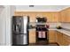 Bright kitchen with light wood cabinets and stainless steel appliances over dark wood flooring at 5153 W Topeka Dr, Glendale, AZ 85308