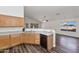 Bright kitchen with light wood cabinets, a black dishwasher, and dark wood flooring at 5153 W Topeka Dr, Glendale, AZ 85308