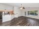 Open-concept space with a breakfast bar, dark wood flooring, and sliding door access to the yard at 5153 W Topeka Dr, Glendale, AZ 85308