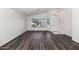 Open-concept space with dark wood flooring, white walls, and large windows with a view of the yard at 5153 W Topeka Dr, Glendale, AZ 85308