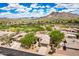 Aerial view of home in desert community with golf course and mountain views at 6214 E Evening Glow Dr, Scottsdale, AZ 85266