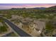 Aerial view of a home, golf course, and mountain views in a meticulously landscaped desert community at 6214 E Evening Glow Dr, Scottsdale, AZ 85266