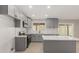 Modern kitchen with gray cabinets, quartz countertops, herringbone backsplash, and stainless steel appliances at 6335 E Brown Rd # 1098, Mesa, AZ 85205