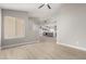 Open-concept living room with light wood floors, neutral paint, ceiling fan, and view into kitchen at 6335 E Brown Rd # 1098, Mesa, AZ 85205