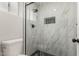 Close up of renovated shower featuring marble tile, black hardware, and a black honeycomb niche at 6335 E Brown Rd # 1098, Mesa, AZ 85205