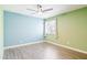 Spacious bedroom featuring two-toned walls, a ceiling fan, hardwood flooring, and bright light at 6540 N 7Th Ave # 46, Phoenix, AZ 85013