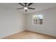 Bright bedroom with neutral walls and flooring, with a window overlooking the fenced yard and desert landscape at 6711 W Osborn Rd # 68, Phoenix, AZ 85033