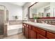 Bright bathroom features a double sink vanity with a tub and tiled shower for a relaxing at-home spa at 6904 W Ashby Dr, Peoria, AZ 85383