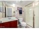 Bathroom with wood vanity, white fixtures, and a glass-enclosed shower stall at 6904 W Ashby Dr, Peoria, AZ 85383