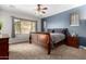 Bright bedroom featuring carpet floors, ceiling fan, and a large window for plenty of natural light at 6904 W Ashby Dr, Peoria, AZ 85383