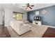 Cozy living room with carpet flooring, comfy sectional sofa, modern entertainment center, and ample natural light at 6904 W Ashby Dr, Peoria, AZ 85383