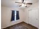 Bedroom features a ceiling fan, plush carpeting, window, and closet with bi-fold doors at 6960 W Peoria Ave # 237, Peoria, AZ 85345