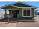 Charming green home with inviting front porch and well-maintained brick landscaping and walkway at 6960 W Peoria Ave # 237, Peoria, AZ 85345