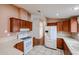 Bright kitchen featuring white appliances, laminate countertops, and wood-look flooring at 6960 W Peoria Ave # 237, Peoria, AZ 85345