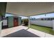 A covered patio area with a shed, artificial turf, and block wall at 6960 W Peoria Ave # 237, Peoria, AZ 85345