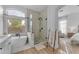 Bright bathroom featuring a soaking tub, a glass-enclosed shower, and ensuite access to the main bedroom at 735 W Ivanhoe St, Gilbert, AZ 85233