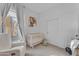 Light, bright Bedroom featuring a crib, comfortable chair, and a large window with sheer curtains at 735 W Ivanhoe St, Gilbert, AZ 85233