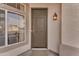 Inviting home entrance featuring a classic door, stylish lighting fixture, and textured wall detail at 735 W Ivanhoe St, Gilbert, AZ 85233