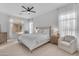 Bright main bedroom featuring a neutral palette, soft carpeting, a ceiling fan, and bright light from large windows at 735 W Ivanhoe St, Gilbert, AZ 85233