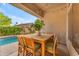 Charming outdoor patio with wooden table set, with a view of the sparkling pool, perfect for alfresco dining at 735 W Ivanhoe St, Gilbert, AZ 85233